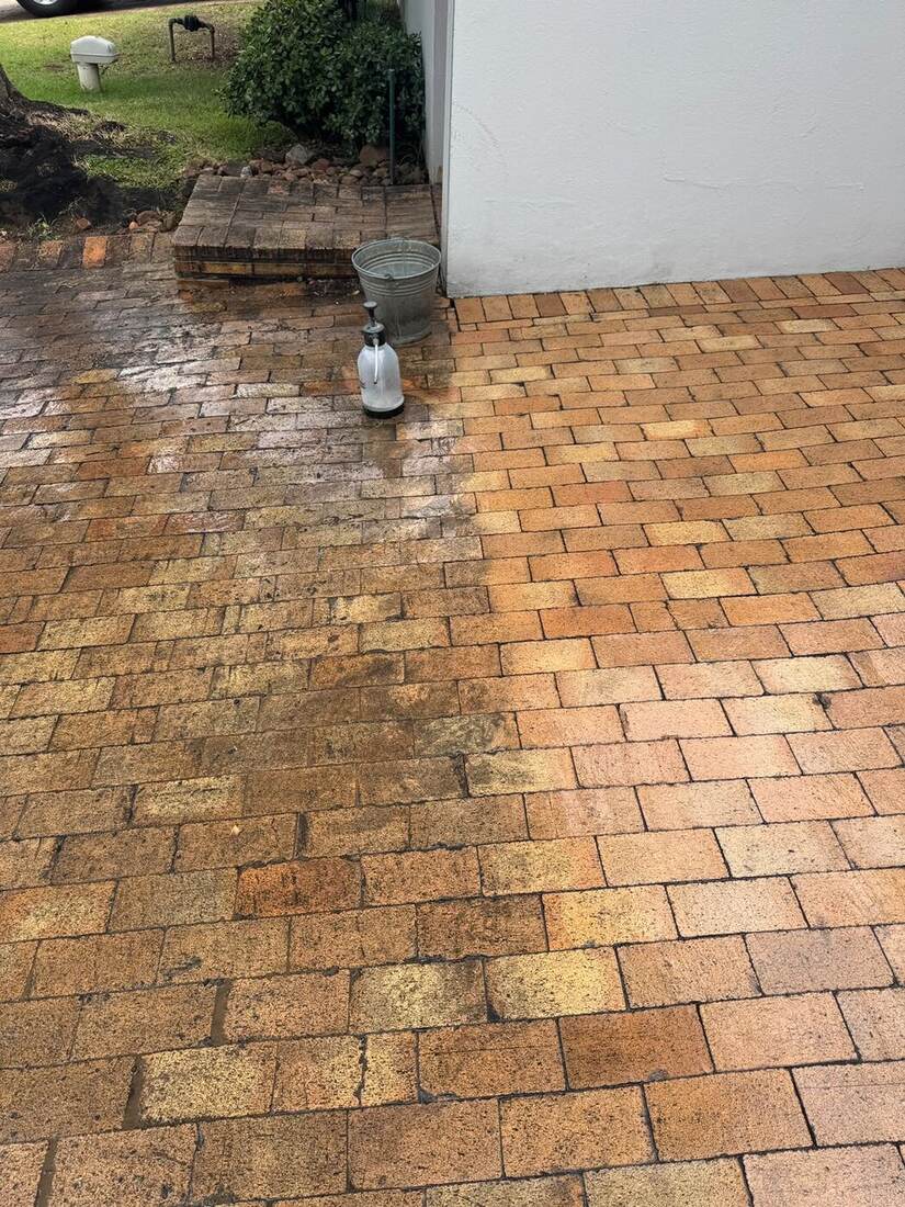 Driveway paving showing a clear line between dirty and freshly cleaned brick